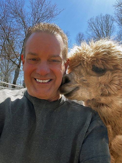 Kevin Cordeiro sharing a quiet moment with an alpaca